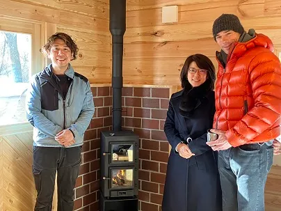 小型クッキング薪ストーブの前でオーナー夫妻と記念撮影